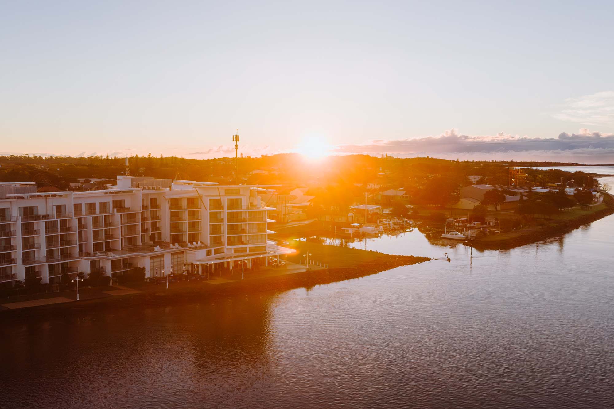 aerial view of the ramada hotel, ballina, northern rivers, nsw taken from over the Richmond River looking back towards Ballina Town Centre at Sunrise.